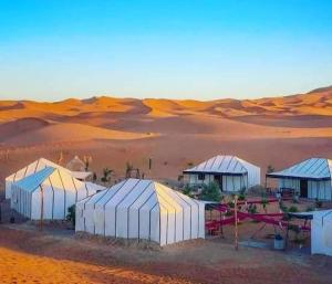 um grupo de tendas no meio de um deserto em Maria Sahara Camp em Merzouga
