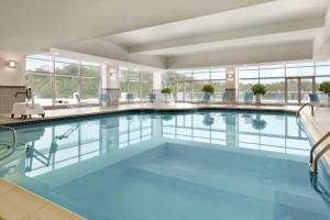 - une grande piscine d'eau bleue dans un bâtiment dans l'établissement Hilton Baltimore BWI Airport, à Linthicum