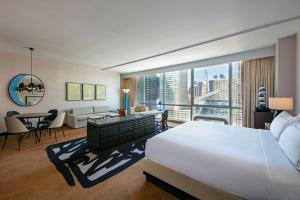 Habitación de hotel con cama grande y ventana grande. en theWit Chicago, a Hilton Hotel en Chicago