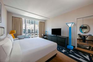 シカゴにあるtheWit Chicago, a Hilton Hotelのベッド、デスク、テレビが備わるホテルルームです。