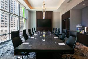 una sala de conferencias con una mesa larga y sillas en theWit Chicago, a Hilton Hotel en Chicago