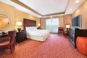 Habitación de hotel con cama y TV en Embassy Suites Murfreesboro - Hotel & Conference Center, en Murfreesboro