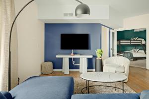 Heart of Olde Town - Urban Retreat - 95 Walk Score في أرفادا: غرفة معيشة مع جدار لكنة زرقاء