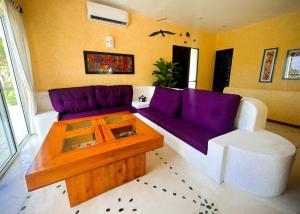 ein Wohnzimmer mit einem lila Sofa und einem Couchtisch in der Unterkunft Villa DALIJÚ in Santa María Huatulco