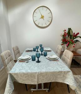 uma mesa de jantar com um relógio na parede em THE ORANGE TREE HOUSES - Terraço by Live and Stay em Abrantes