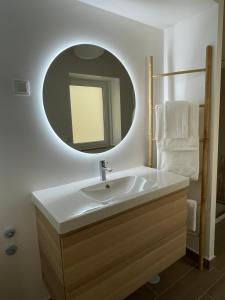 uma casa de banho com um lavatório e um espelho em THE ORANGE TREE HOUSES - Terraço by Live and Stay em Abrantes