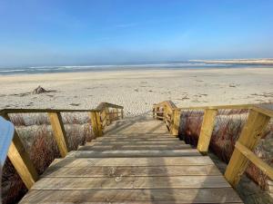 un paseo marítimo de madera que conduce a la playa en GARDEN & BEACH HOUSE, en Figueira da Foz