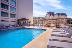 a swimming pool with lounge chairs and a hotel at Hilton Québec in Quebec City