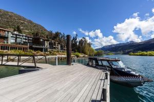 a boat is docked at a dock on a river at Hilton Queenstown Resort & Spa in Queenstown