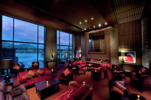 una gran sala de estar con muebles de color rojo y ventanas grandes. en Hilton Queenstown Resort & Spa en Queenstown