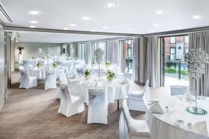a banquet hall with white tables and white chairs at DoubleTree by Hilton Queenstown in Queenstown