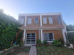 a brick house with windows and plants in a yard at Green House.river in Rosario