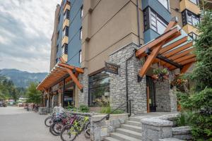 a group of bikes parked outside of a building at Prime Village Ski In Ski Out Location by Harmony Whistler in Whistler