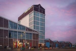 a tall building with a sign on top of it at DoubleTree by Hilton Amsterdam - NDSM Wharf in Amsterdam