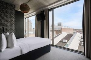 a bedroom with a bed and a large window at DoubleTree by Hilton Amsterdam - NDSM Wharf in Amsterdam +59 photos