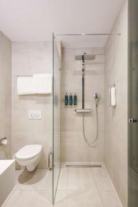 a bathroom with a shower and a toilet at DoubleTree by Hilton Amsterdam - NDSM Wharf in Amsterdam