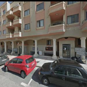 two cars parked in a parking lot in front of a building at you can enjoy your time at waterford apartment in Attard