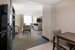 a living room with a kitchen and a dining room at Best Western Plus Daytona Inn Seabreeze in Daytona Beach