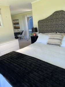 a bedroom with a bed with a black and white comforter at Riverside Bliss in Clive