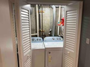 een kleine kamer met 2 wasmachines en een wasmachine en droger bij Boston Single Family House - Super Quiet and Private in Boston