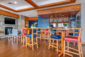 a kitchen with a bar with chairs and a fireplace at Bangor Aviator Hotel BW Premier Collection in Bangor