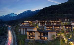 an aerial view of a building with mountains in the background at Conrad Jiuzhaigou in Jiuzhaigou