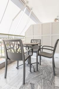 twee stoelen en een tafel op een dak bij Hotel Melissanthi in Paralia Dionysiou