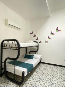 Habitación con 2 literas con mariposas en la pared en Believer Hostel en Santa Marta