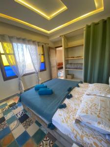 1 dormitorio con 1 cama grande con sábanas azules en Dar KOUJANE villa avec piscine, 