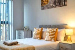 een slaapkamer met een bed met oranje en witte kussens bij Birmingham City Center - Luxury Stay 86 in Birmingham