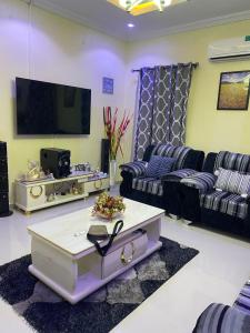 a living room with couches and a flat screen tv at 3 Bedroom Spacious Apartment in Okunola