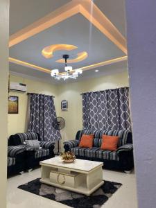 a living room with couches and a coffee table at 3 Bedroom Spacious Apartment in Okunola