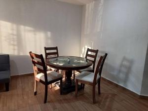uma mesa de jantar com 4 cadeiras e uma mesa e uma mesa e uma espreguiçadeira em Casa Villa (facturamos) em Los Mochis