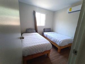 Cette petite chambre comprend 2 lits et une fenêtre. dans l'établissement Casa Villa (facturamos), à Los Mochis