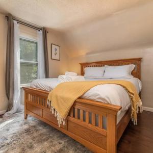 1 dormitorio con 1 cama grande con sábanas blancas y ventana en Entire house 3 bedroom Twin Cities, Specious, Entire House, AC, en Saint Paul