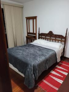 1 dormitorio con cama y alfombra roja en Casa Maciel, en São Thomé das Letras