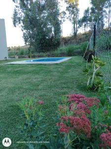 un patio con piscina y flores en Los nogales en Tandil