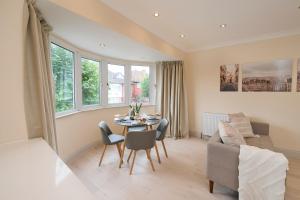 a living room with a table and chairs and a couch at Stylish 4Bed 2 Bath, NW London Large Apartment in London