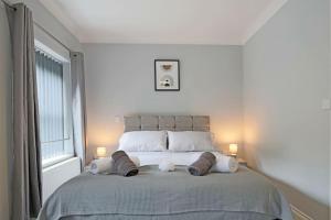 a bedroom with a large bed with two lamps at Deluxe & Modern 2bed House in Derby