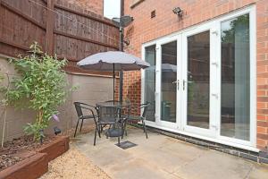patio ze stołem, krzesłami i parasolem w obiekcie Deluxe & Modern 2bed House w mieście Derby