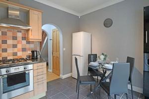 a kitchen with a table and a white refrigerator at Deluxe & Modern 2bed House in Derby