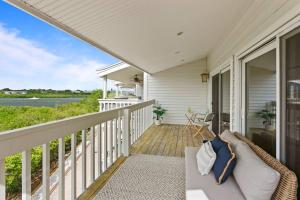 um alpendre com um sofá e vista para a água em BRAND NEW, Water Views, 2 BD Condo em Clearwater Beach