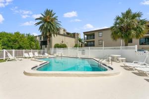 a swimming pool with lounge chairs and a building at BRAND NEW, Water Views, 2 BD Condo in Clearwater Beach