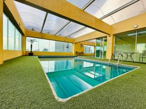 an indoor swimming pool in a house with a large ceiling at Hotel Villa Florida Puebla in Puebla