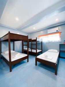 a room with three bunk beds in it at In Dai Aquasports and Beach Resort in Bantayan Island