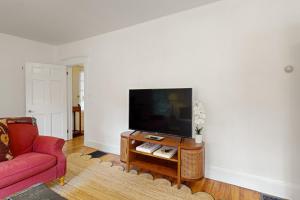 un soggiorno con divano rosso e TV a schermo piatto di The Farmhouse B&B a Montpelier