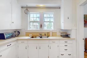 a white kitchen with a sink and a microwave at The Farmhouse B&B in Montpelier