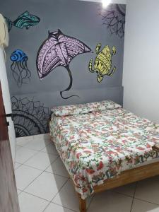 a bedroom with a bed and a wall with drawings on it at Casa do Cais in Abraão +4 photos