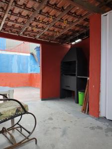 a room with a red wall and a chair in it at Casa do Cais in Abraão