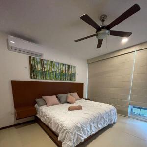 Schlafzimmer mit einem Bett und einem Deckenventilator in der Unterkunft Condominio uaymitun,progreso in Uaymitun